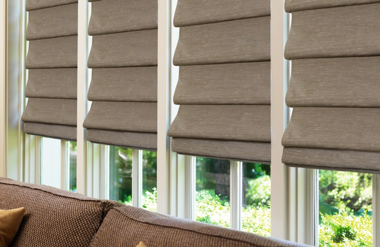 Decorative Roman shades in brown in sunroom window